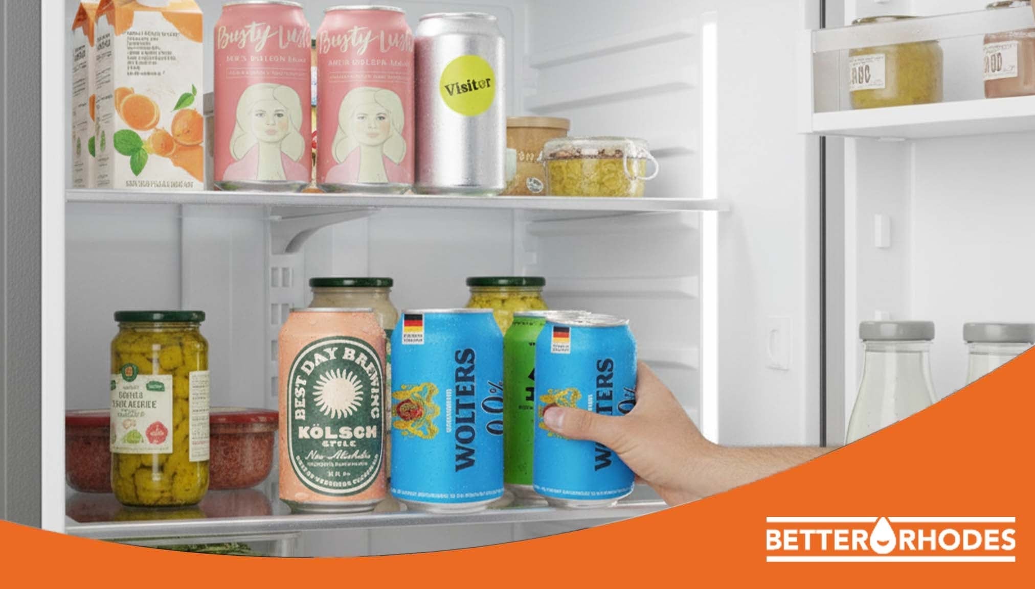 Hand reaching into a fridge stocked with non-alcoholic beers and drinks for Dry January