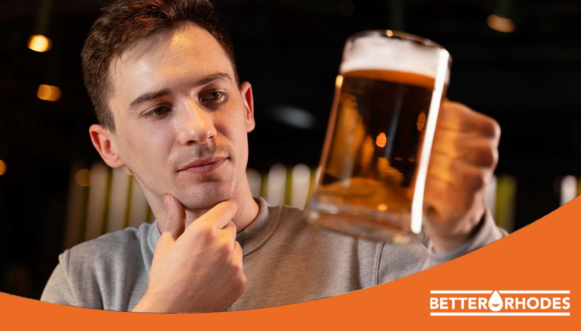 Man examining a glass of non-alcoholic beer