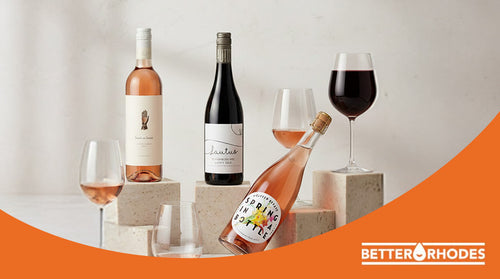 Non-alcoholic wine bottles and glasses displayed on stone pedestals