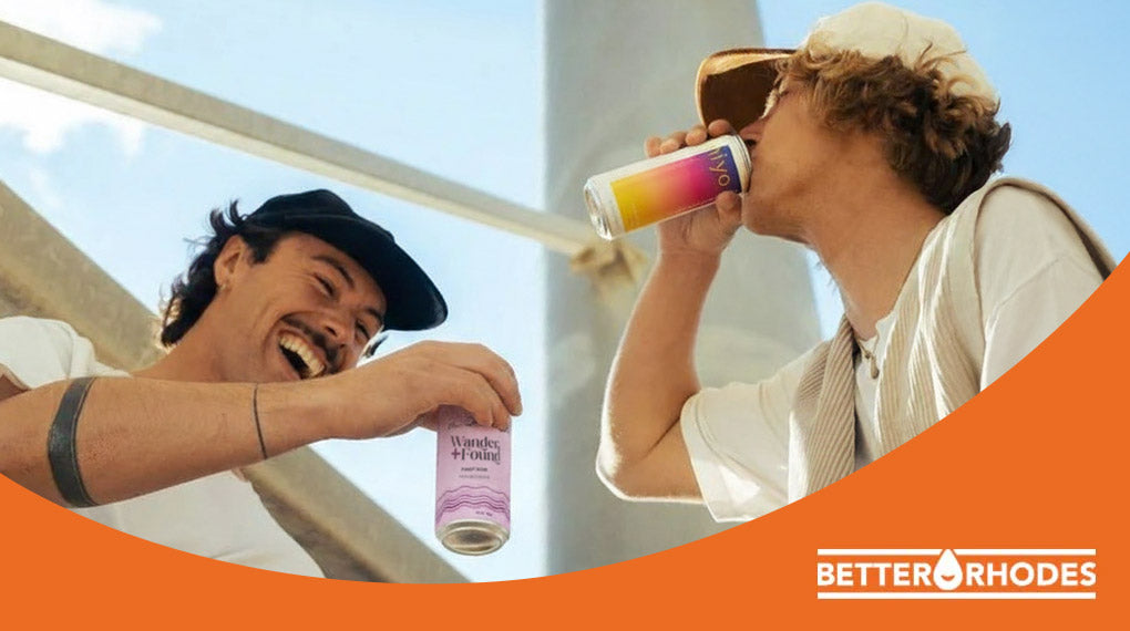 Two friends laughing and enjoying canned non-alcoholic drinks